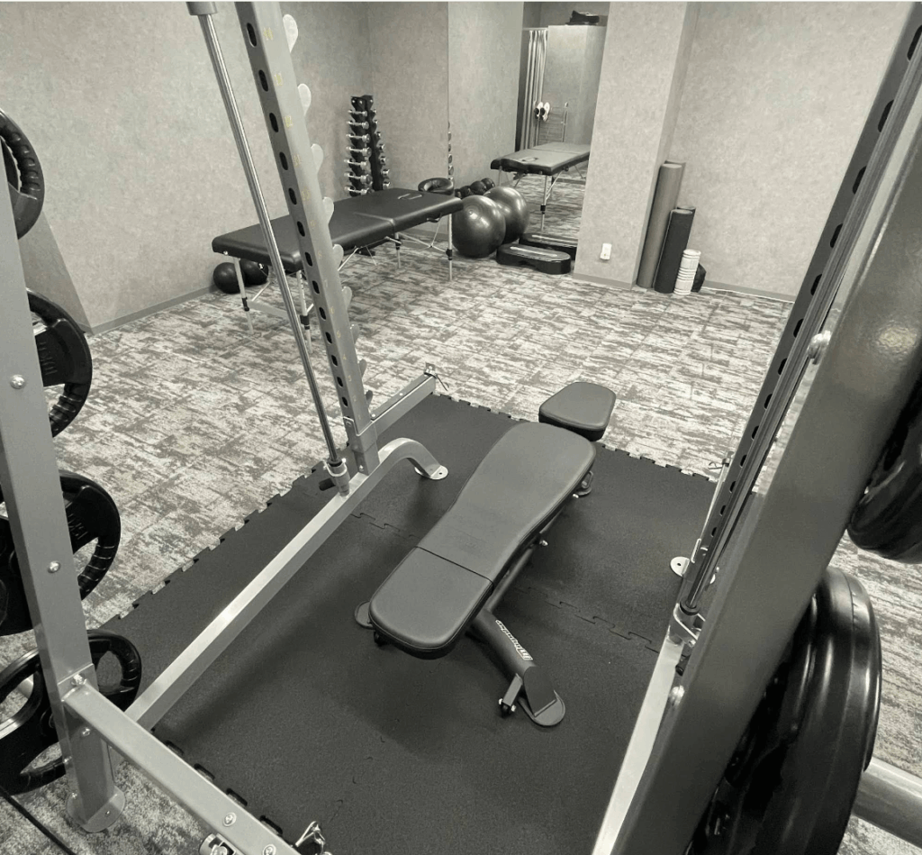 Anchorageジムのベンチとダンベルラックのトレーニングエリア